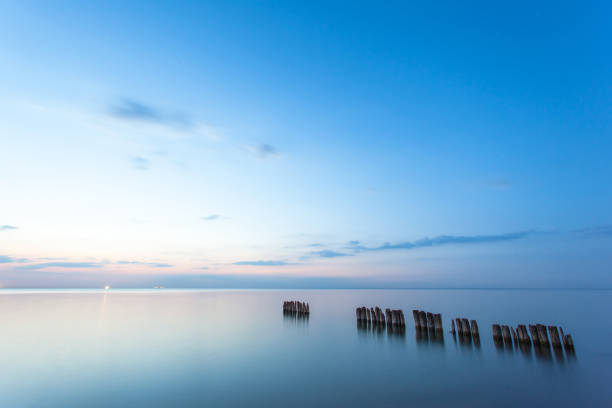 istock smooth sea surface and breakwaters in blue twilight on long exposure 1131758476