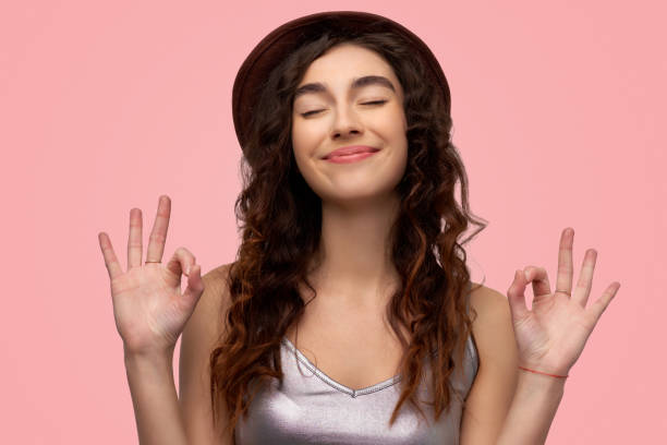 istock Cheerful brunette young female with glad expression, shows ok sign with both hands, dressed in casual white t shirt, demonstrates approval 1131763873