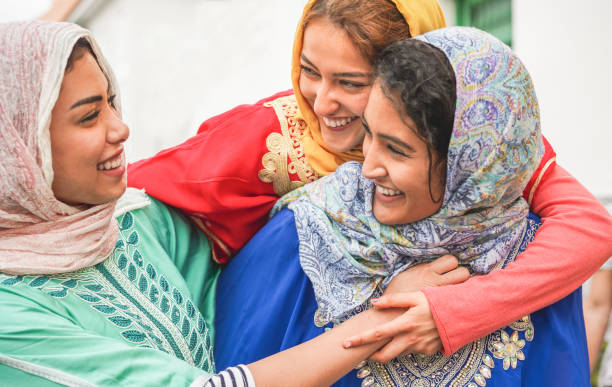 les jeunes amis islamiques ayant l'amusement en plein air-amis arabes heureux riant et souriant ensemble-l'amitié, la religion, la culture ethnique et le concept de jeunesse-se concentrer sur le visage de fille supérieure - tradition marocaine photos et images de collection