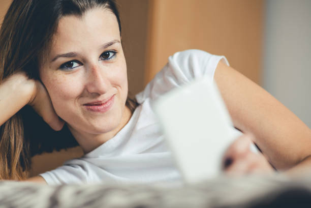 istock Woman lying on bed and using mobile phone. 1131765902