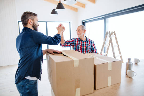 A mature man with his senior father furnishing new house, a new home concept. A portrait of mature man with his senior father shaking hands when furnishing new house, a new home concept. Copy space. seniors-moving-house stock pictures, royalty-free photos & images