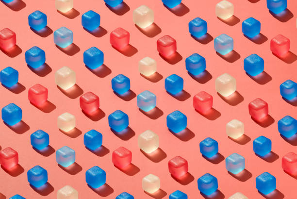 istock Diagonal rows pattern from colored plastic ice cubes on a background in a trend color of the year 2019 Living Coral Pantone. 1131768897