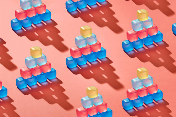 istock Creative pattern of pyramids from plastic colorful ice cubes on a background in a trend color of the year 2019 Living Coral Pantone. 1131768901