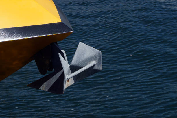 Bow of a yellow sailing yacht  against the blue sea with anchor at the bow. copy space, selective focus, narrow depth of field