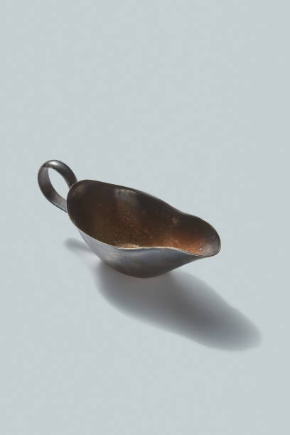 istock Retro bronze sauceboat with shadows on a white background. Vintage kitchenware. 1131768999