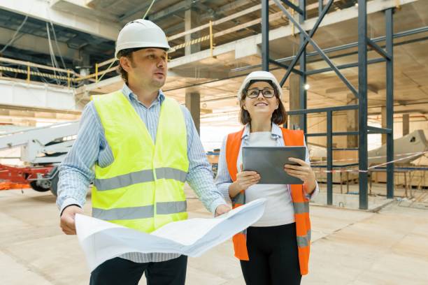 istock Male building workers working at construction site, builders looking in blueprint. Building, development, teamwork and people concept 1131769512