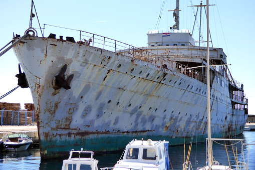 Vintage grungy white ship stern with green waterline and portholes