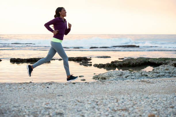 istock An athletic woman running on a beach at sunset. 1131777517