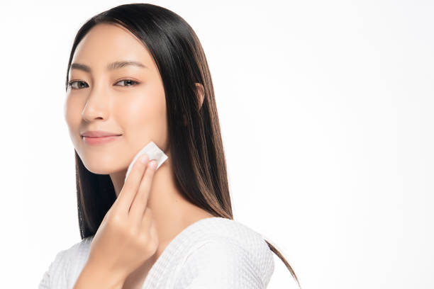 szczęśliwa uśmiechnięta piękna azjatka używająca wacika czyszczącego skórę - human face rubbing women beauty treatment zdjęcia i obrazy z banku zdjęć