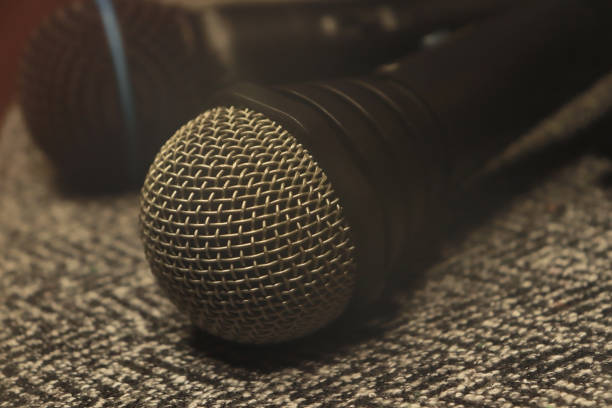 istock two microphones lie on a gray cloth in the fog 1131782921