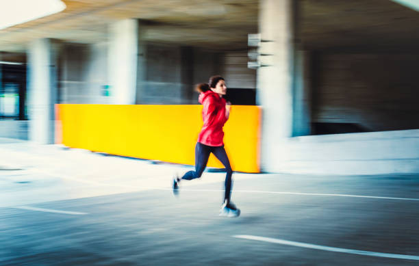 istock Young Woman Running in an Urban Environment, Blurred motion 1131782955