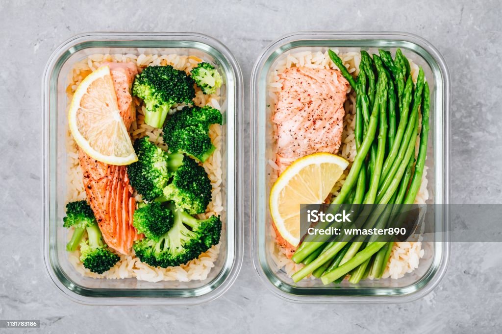 Contenitori per la scatola per il pranzo di preparazione dei pasti con pesce salmone al forno, riso, broccoli verdi e asparagi - Foto stock royalty-free di Preparazione di alimenti