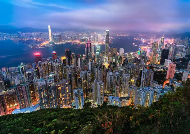 Beautiful light scenery of Hong Kong viewed from the top of Victoria Peak with city skyline of crowded skyscrapers.