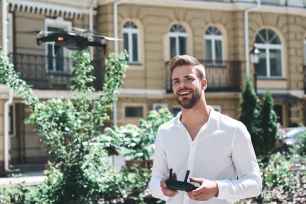 istock Young man control drone while sitting at pier in old european city 1131784765