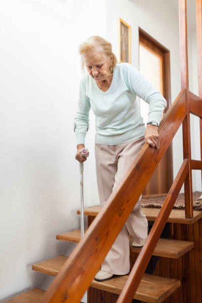 istock Elderly woman at home using a cane to get down the stairs 1131785961