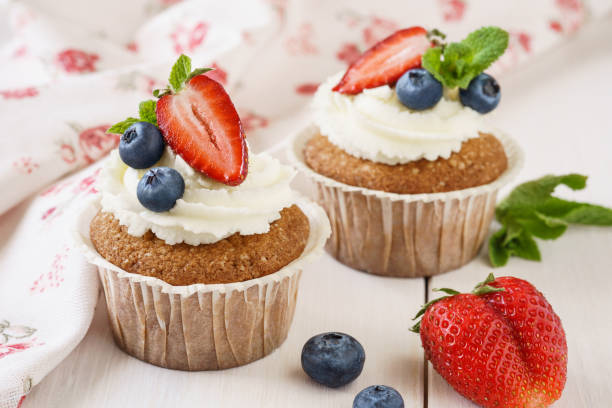 istock Vanilla cupcakes with fresh mint, strawberry and blueberries. 1131786111