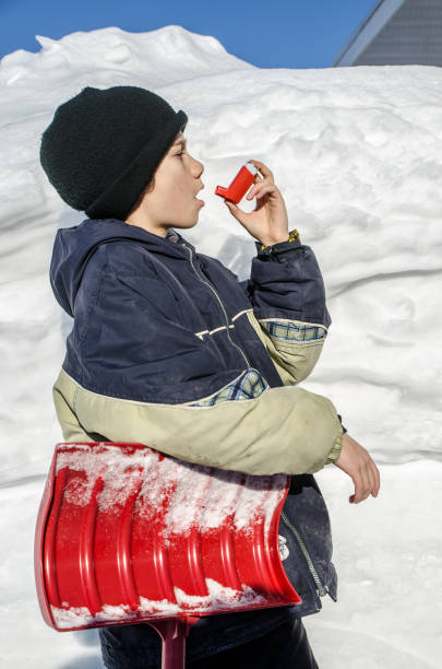 istock Young boy using asthma pump after snow shoveling 1131788942