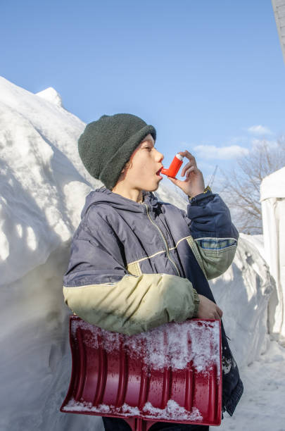 istock Young boy using asthma pump after snow shoveling 1131788953