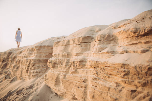 istock tired girl walking sand desert beach footprints 1131791670