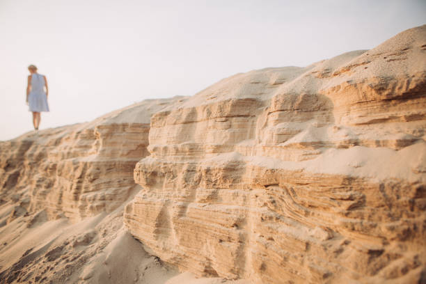 istock tired girl walking sand desert beach footprints 1131791675