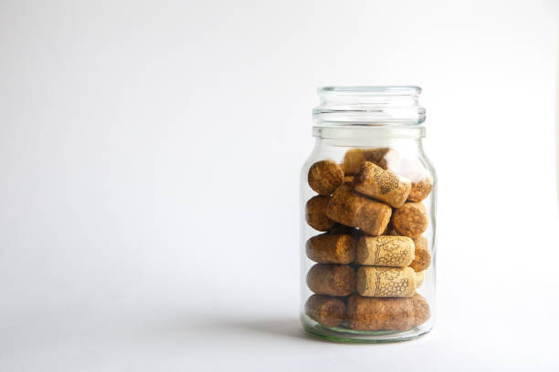 istock Wine corks lie in a glass jar on a white background 1131796181