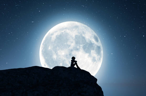 istock Lonely girl sitting alone on the cliff 1131797148