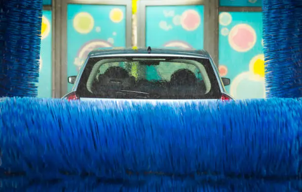 Photo of Automatic car wash in action, car wash clean, brushes. Soft focus