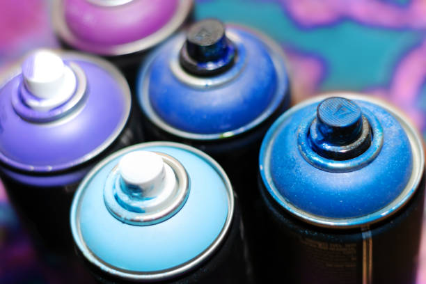 istock blue and violet spray cans on graffiti on an isolated white background close-up 1131809220