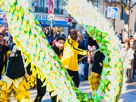 PARIS, FRANCE - FEBRUARY 17, 2019. Last day of the chinese new year celebration festival in street. Dance of colorful green dragons in the street during the parade festival. Traditional celebration.