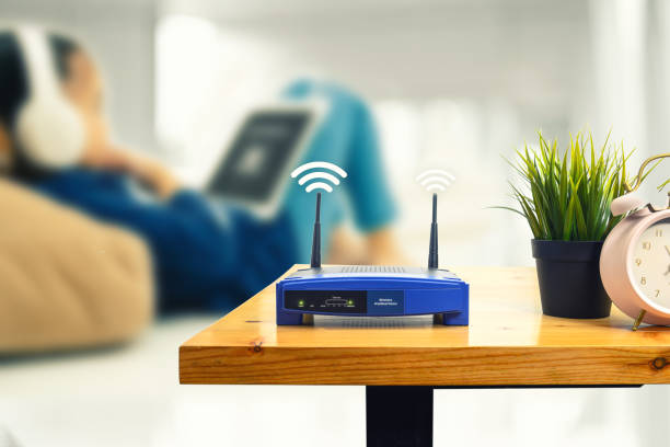 primo piano di un router wireless e di un uomo che usa lo smartphone sul soggiorno a casa ofiice - tecnologia mobile foto e immagini stock