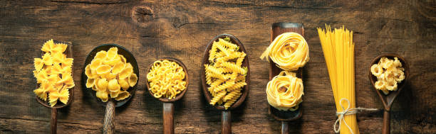 istock Various pasta on spoons over wooden background 1131812173