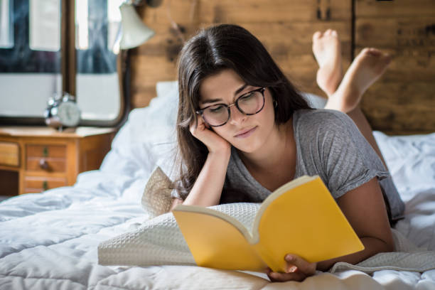 istock woman laying in bed and reading book 1131814940