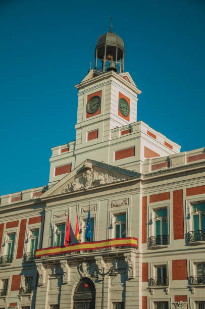 istock Flags on exquisite old building with bell tower and clock in Madrid 1131816372
