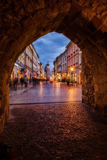 puerta y calle de florianska en cracovia al anochecer - florianska street fotografías e imágenes de stock