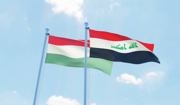 istock Iraq and Hungary, two flags waving against blue sky 1131818596