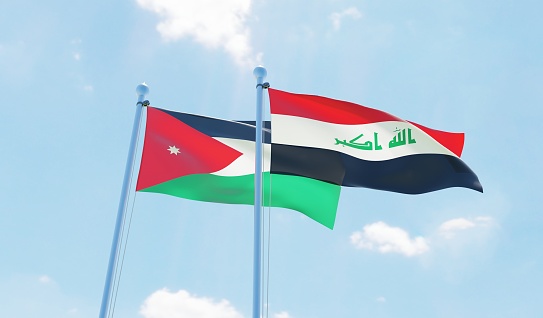 Irak y Jordania, dos banderas agitando contra el cielo azul photo