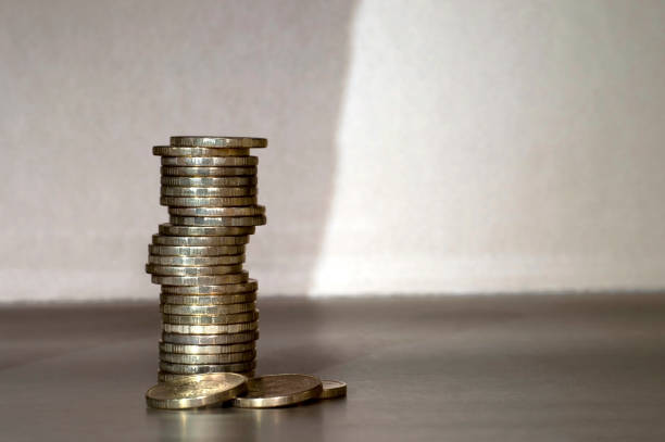 istock Yellow shiny coins stacked in a pile on the differentiated light shadow background. The concept of tax evasion 1131821756