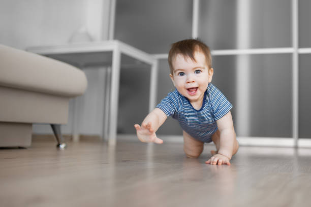 happy crawling baby boy at home on the floor