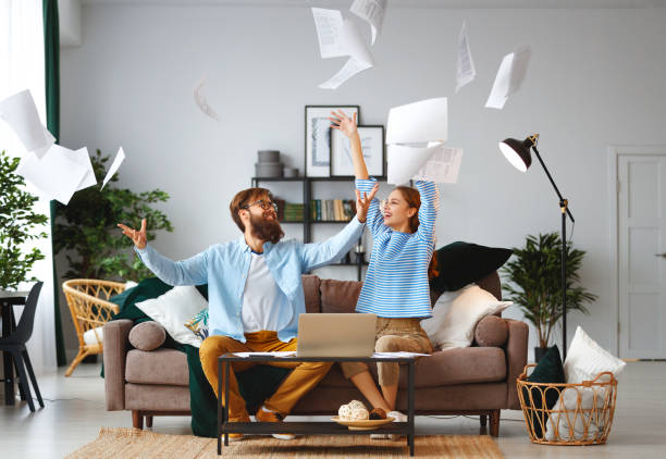 married couple with bills receipts documents and laptop at home married couple with bills receipts documents and a laptop at home throwing stock pictures, royalty-free photos & images