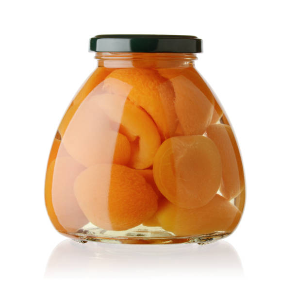 istock Sliced ​​apricot in a glass jar isolated on white 1131827303