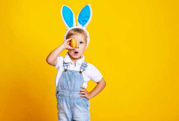 istock funny happy child boy with easter eggs and bunny ears on yellow 1131827315