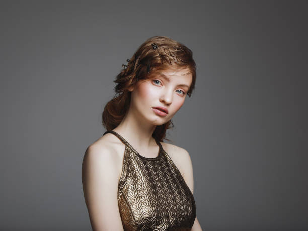 Portrait of a girl with a fiery golden make-up shot using the technique of mixed light