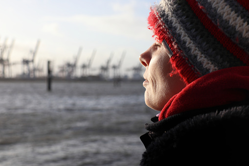 Woman enjoying the sun on a winter day at the river Elbe in Hamburg, Germany