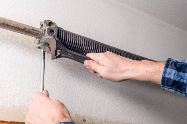 istock Home repairman uses tools to work on a garage door spring 1131832056