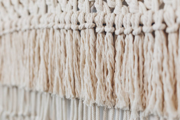Detail of macrame decor displayed hanging on a wall. Macrame decor displayed hanging on a wall. macrame stock pictures, royalty-free photos & images