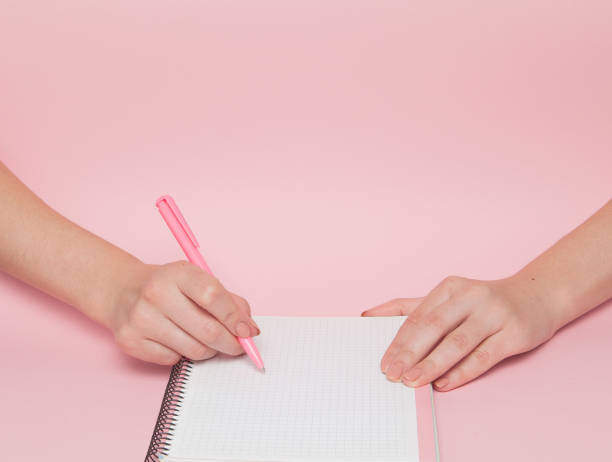 istock Notebook and pen in hand on pink background with copy space.Business Concept and Instagram 1131833412