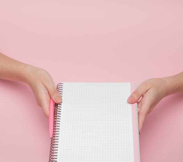 istock Notebook and pen in hand on pink background with copy space.Business Concept and Instagram 1131833414