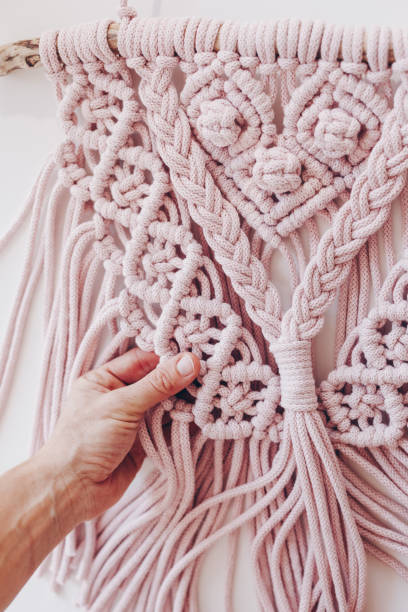 istock Close up of female hands weaving macrame in a home workshop. 1131834275