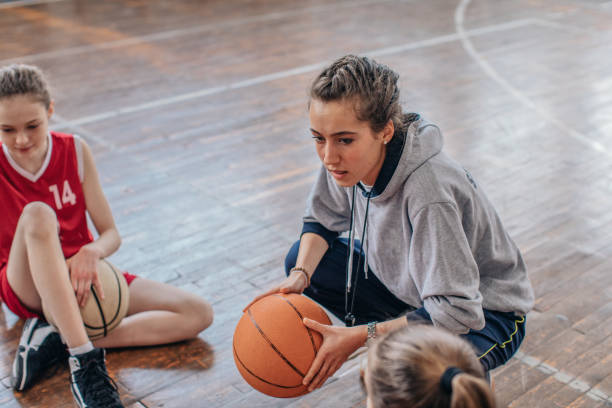 istock Female coach sitting with basketball team 1131834310