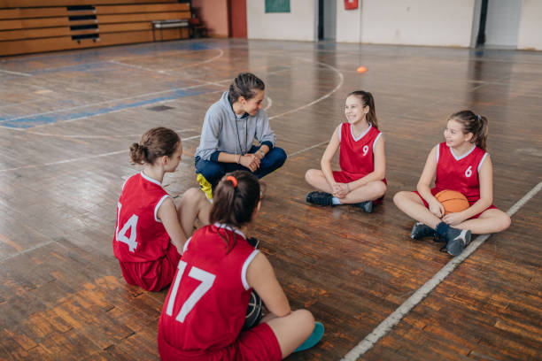 istock Female coach sitting with basketball team 1131834343